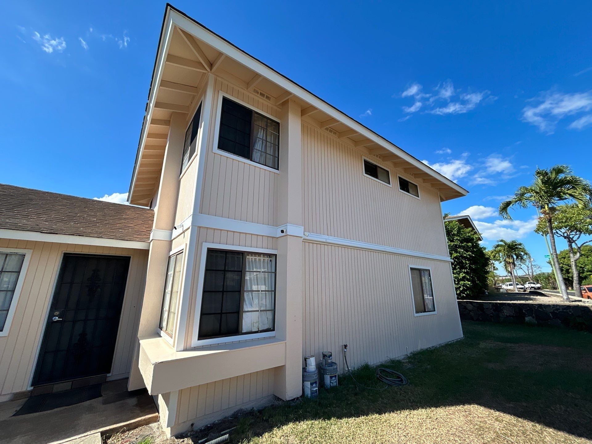 Two-story home exterior repainted in cream and white in Honolulu, HI
