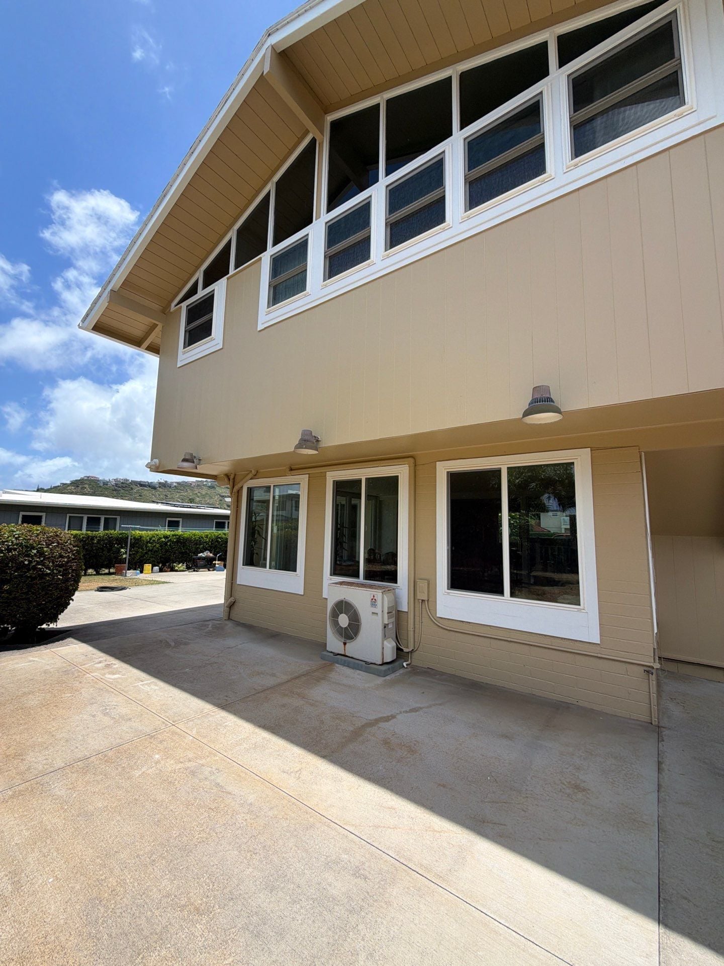 Two-story home exterior repainted in tan with brown trim in Kapolei, Oahu