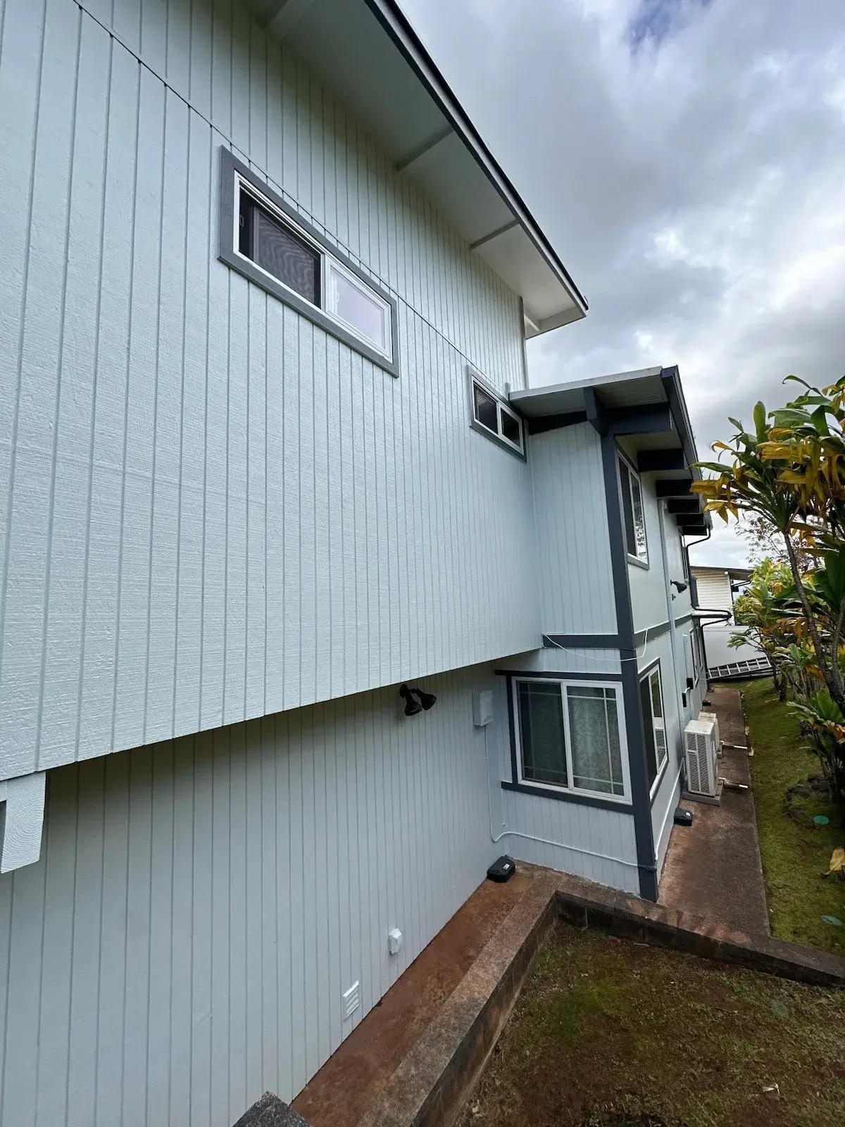 Side elevation of a home repainted in pale blue-green in Maui, Hawaii